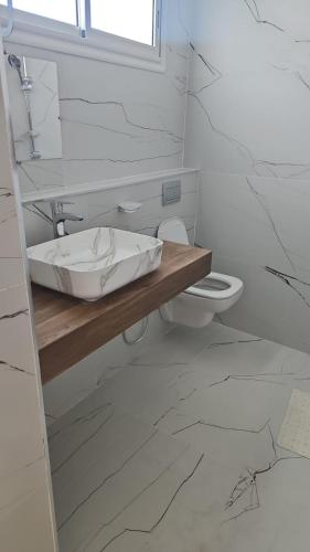 a bathroom with a sink and a toilet at Villa Ayem avec piscine à l'étage in Al Ḩārah al Kabīrah