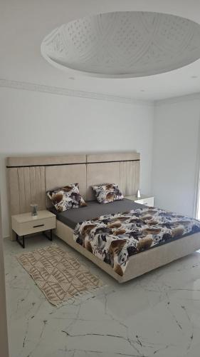 a bedroom with a bed with a cow blanket at Villa Ayem avec piscine à l'étage in Al Ḩārah al Kabīrah