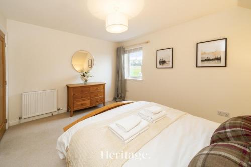 a bedroom with a bed and a mirror on the wall at Bonnieview House, Tarves, Aberdeenshire 