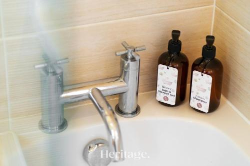 a bathroom sink with two bottles of soap at Bonnieview House, Tarves, Aberdeenshire 