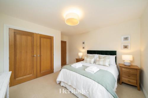a bedroom with a large bed and a wooden door at Bonnieview House, Tarves, Aberdeenshire 