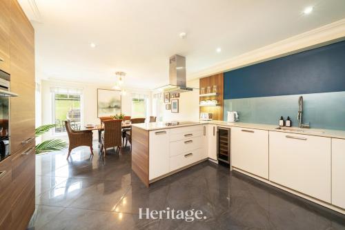 a kitchen with white cabinets and a dining room at Bonnieview House, Tarves, Aberdeenshire 