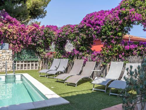 a group of chairs sitting in the grass with purple flowers at Elegant Seaside Villa in Èze in Èze