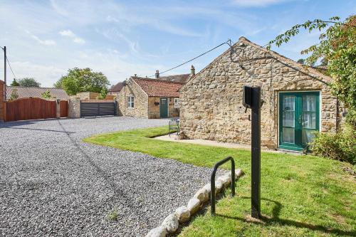 a stone house with a pole in the yard at Host & Stay - Hutton-le-Hole Cottages in Hutton le Hole