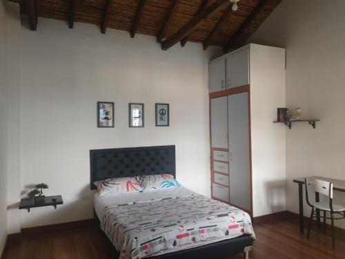 - une chambre avec un lit, une armoire et une table dans l'établissement Apartaestudios tipo loft Prado Station, à Medellín