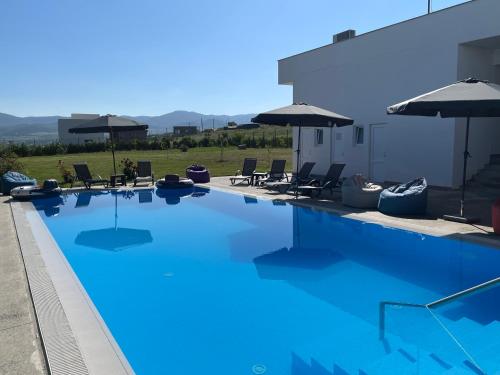 a large blue swimming pool with chairs and umbrellas at DREAM VIEW Saguramo in Saguramo