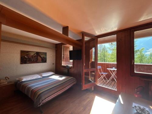 a bedroom with a bed and a balcony at Cervinia Snow Dream Apartments in Breuil-Cervinia
