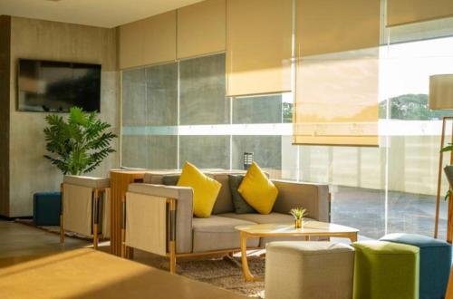 a living room with a couch and yellow pillows at AEON TOWERS 1BR unit beside abreeza mall in Davao City