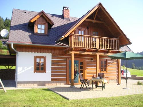a house with a deck and a table and an umbrella at Peaceful Mountain Holiday Stay in Stupná