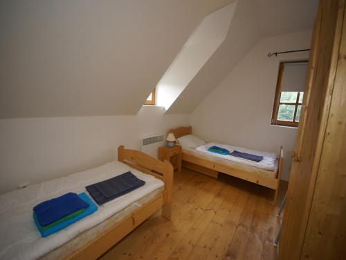 a small room with two beds and a window at Peaceful Mountain Holiday Stay in Stupná