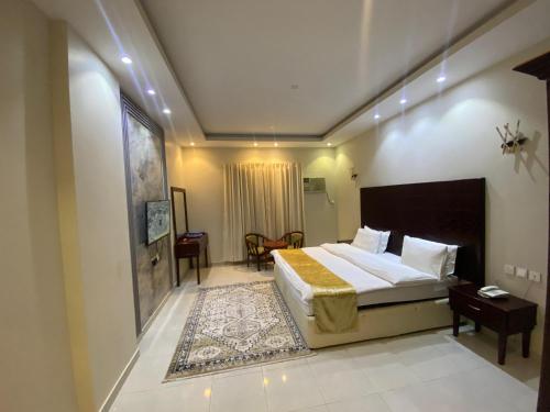 Un dormitorio con una cama grande y una mesa. en نجوم القريات 2للاجنحة المخدومة, en Al-Qurayat