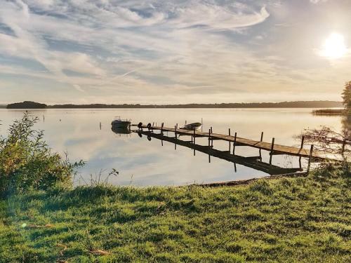 a dock on a lake with a boat in the water at 4 person holiday home in KRISTIANSTAD-By Traum in Kristianstad