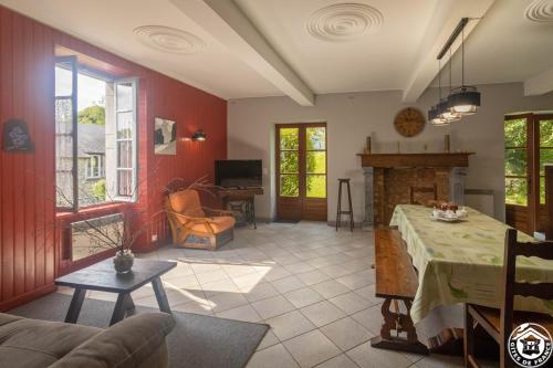 un soggiorno con tavolo e camino di Maison Chez Caussade a Peyrouse