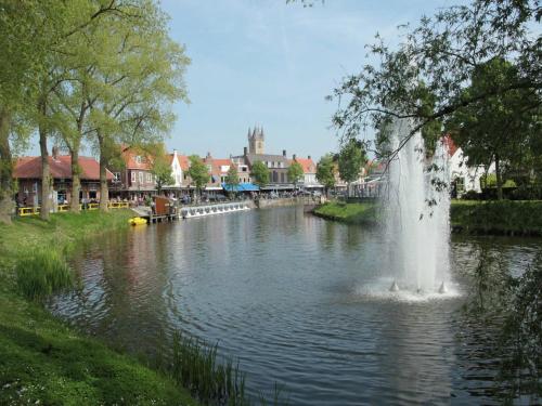 a fountain in the middle of a river at Spacious Countryside Villa in Zuidzande