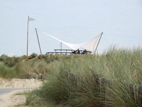 a building on top of a beach with grass at Spacious Countryside Villa in Zuidzande