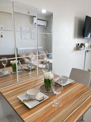 a wooden table with wine glasses and flowers on it at Haven Staycation by Alexa Grace in Lapu Lapu City