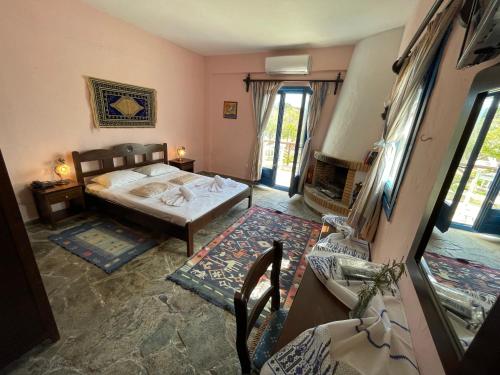 a bedroom with a bed and a fireplace at Arolithos Traditional Village Hotel in Tílisos