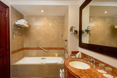 a bathroom with a tub and a sink and a mirror at JW Marriott Caracas in Caracas