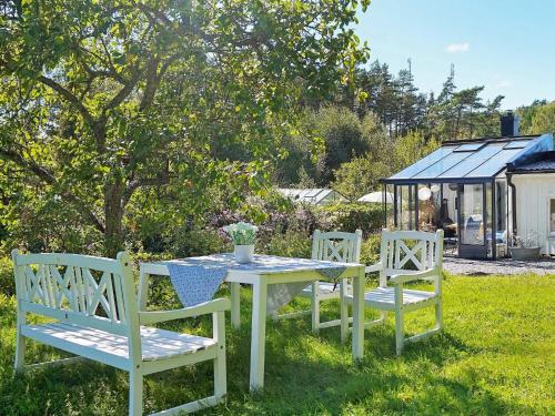 a white table and two chairs sitting in the grass at 8 person holiday home in FAGERFJÄLL RÖNNÄNG in Bräcke