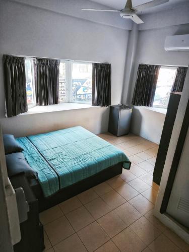 a bedroom with a bed and two windows at TM Room For Rent in Pattaya