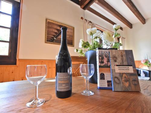 a bottle of wine sitting on a table with two glasses at Holiday Home in Le Châtelet with Pool in Le Châtelet