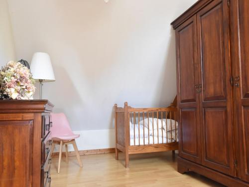 a room with a crib and a dresser next to a bedroom at Holiday Home in Le Châtelet with Pool in Le Châtelet