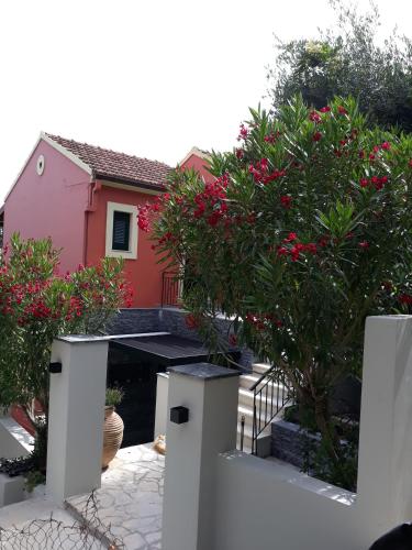 a house with a pink house and some flowers at Milka Studios in Barbati