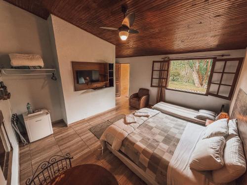 a bedroom with a large bed and a window at Pousada Acalanto in São Roque