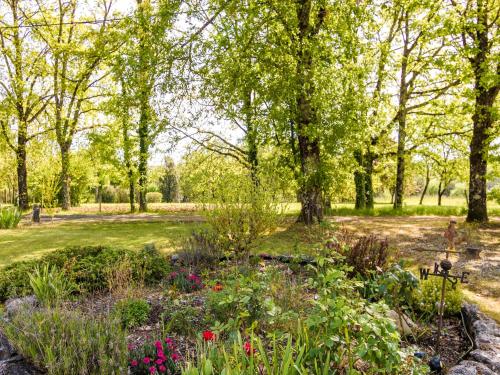 a garden with flowers and trees in a park at Caves & Castles Escape in Nadaillac-de-Rouge