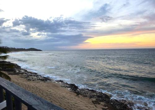 a view of the ocean from a beach at sunset at Ventana Va101 at Arecibo 681 Ocean Drive in Arecibo