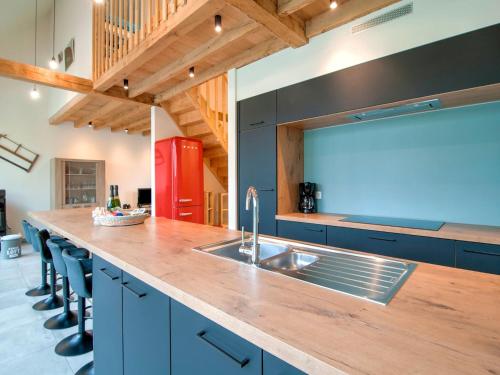a kitchen with a sink and a counter with blue cabinets at Bocholt Family Home, Bocholt in Bocholt