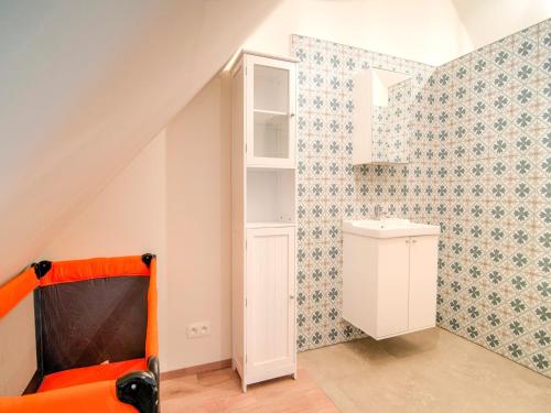 a room with an orange chair and a white cabinet at Bocholt Family Home, Bocholt in Bocholt