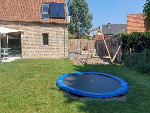 a blue trampoline in a yard with a playground at Bocholt Family Home, Bocholt in Bocholt