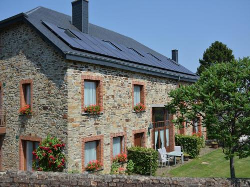 a stone house with solar panels on the roof at Spacious retreat, Daverdisse in Daverdisse