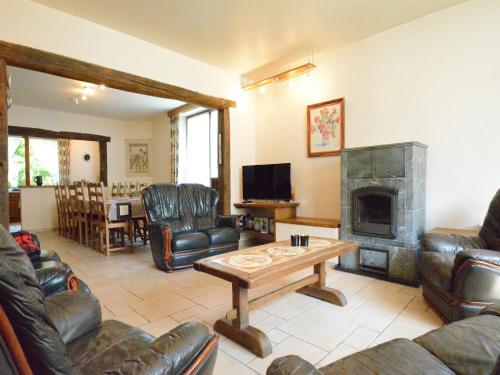 a living room with leather furniture and a fireplace at Spacious retreat, Daverdisse in Daverdisse