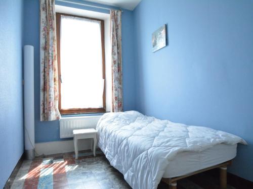 a blue bedroom with a bed and a window at Spacious retreat, Daverdisse in Daverdisse