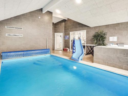 a large swimming pool with a slide in a room at Luxury Retreat with Pool - By Traum Ferienwohnungen in Jægerspris