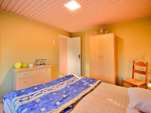 a bedroom with a bed and a cabinet and a chair at Holiday Home in Hollebeke with Private Garden in Zandvoorde