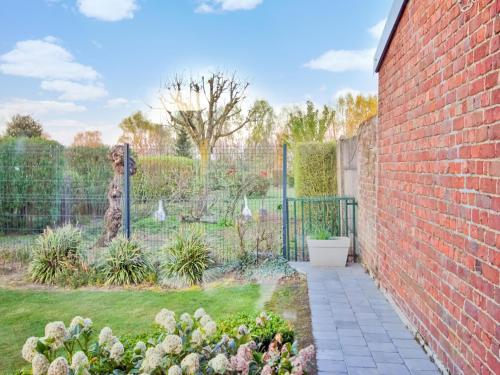 a garden with a brick wall and a fence at Holiday Home in Hollebeke with Private Garden in Zandvoorde