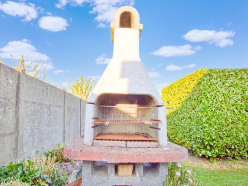 a pizza oven sitting next to a wall at Holiday Home in Hollebeke with Private Garden in Zandvoorde