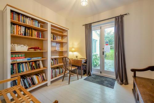 a room with bookshelves and a desk and a table at Hywelfa in Abersoch