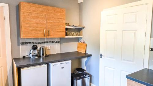 a small kitchen with a counter and a refrigerator at Tree Tops by StayStaycations in Glyncorrwg