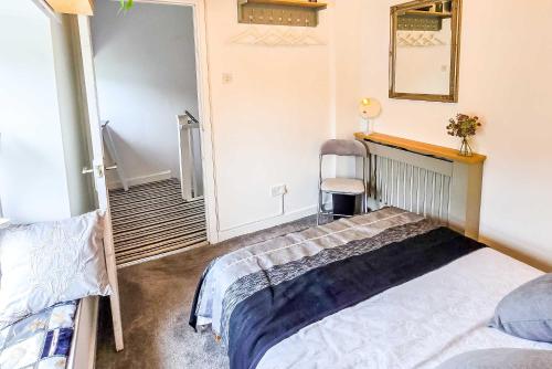 a bedroom with a bed and a mirror on the wall at Tree Tops by StayStaycations in Glyncorrwg