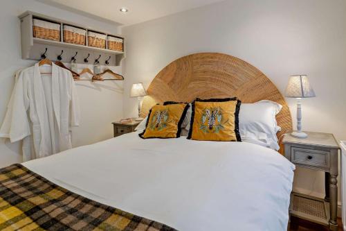 Un dormitorio con una gran cama blanca con almohadas amarillas. en Ty-Llew Hideaway, en Abergavenny