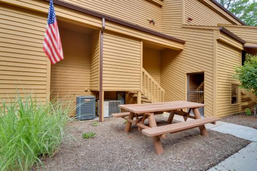 a picnic table in front of a building with an american flag at Harbor Springs Condo about 6 Mi to Lake Michigan! in Harbor Springs
