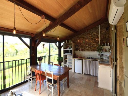 eine Küche und ein Esszimmer mit einem Holztisch in der Unterkunft Loubejac Garden Escape in Saint-Cernin-de-lʼHerm
