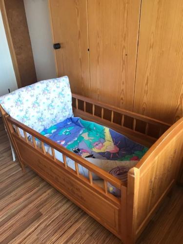 a wooden crib with a chair in a room at Ruhige Zimmer im Grünen und Studio im Naherholungsgebiet in Sigigen