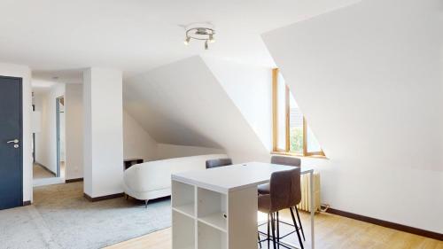a white room with a bed and a table and chairs at Les jardins de Bouvignies in Bouvignies