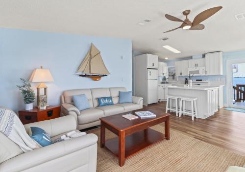 a living room with a couch and a table and a kitchen at Oceanview Retreat with 60ft Seawall in Cudjoe Key