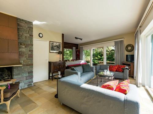 een woonkamer met een bank en een open haard bij Oostduinkerke Forestside Villa in Oostduinkerke